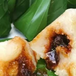 Sepiring lapet khas Batak dengan tekstur kenyal dan rasa manis gurih, disajikan di atas daun pisang untuk cita rasa yang autentik