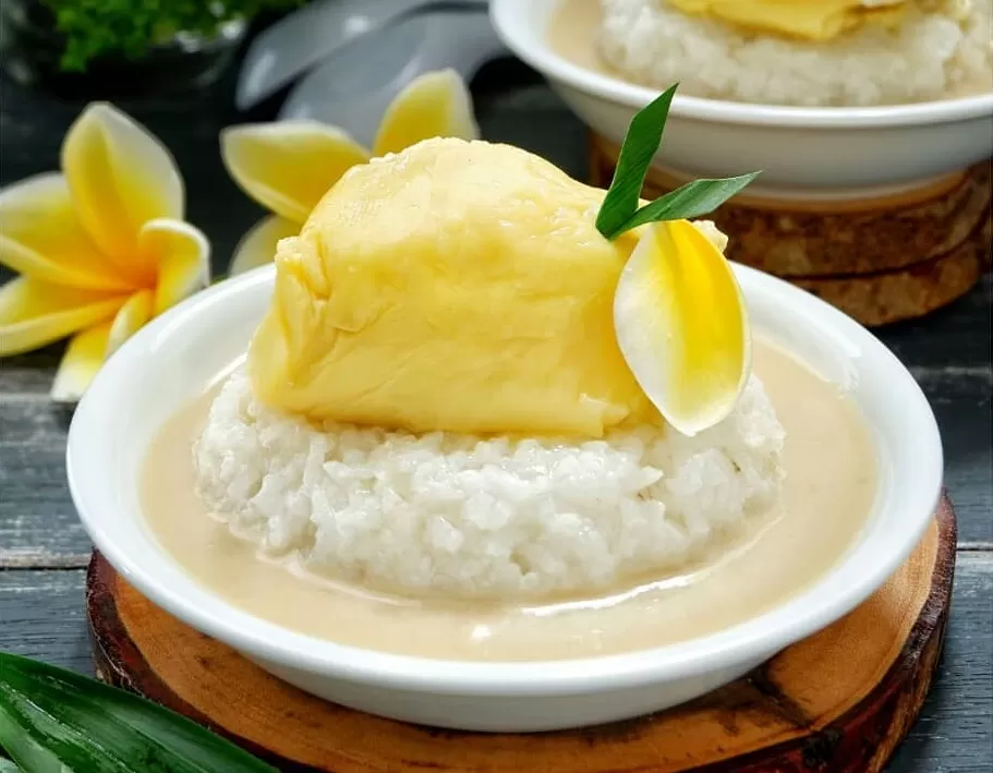 Ketan Durian yang Lezat: Sepiring ketan putih yang pulen disajikan dengan durian manis yang menggugah selera, siap untuk dinikmati